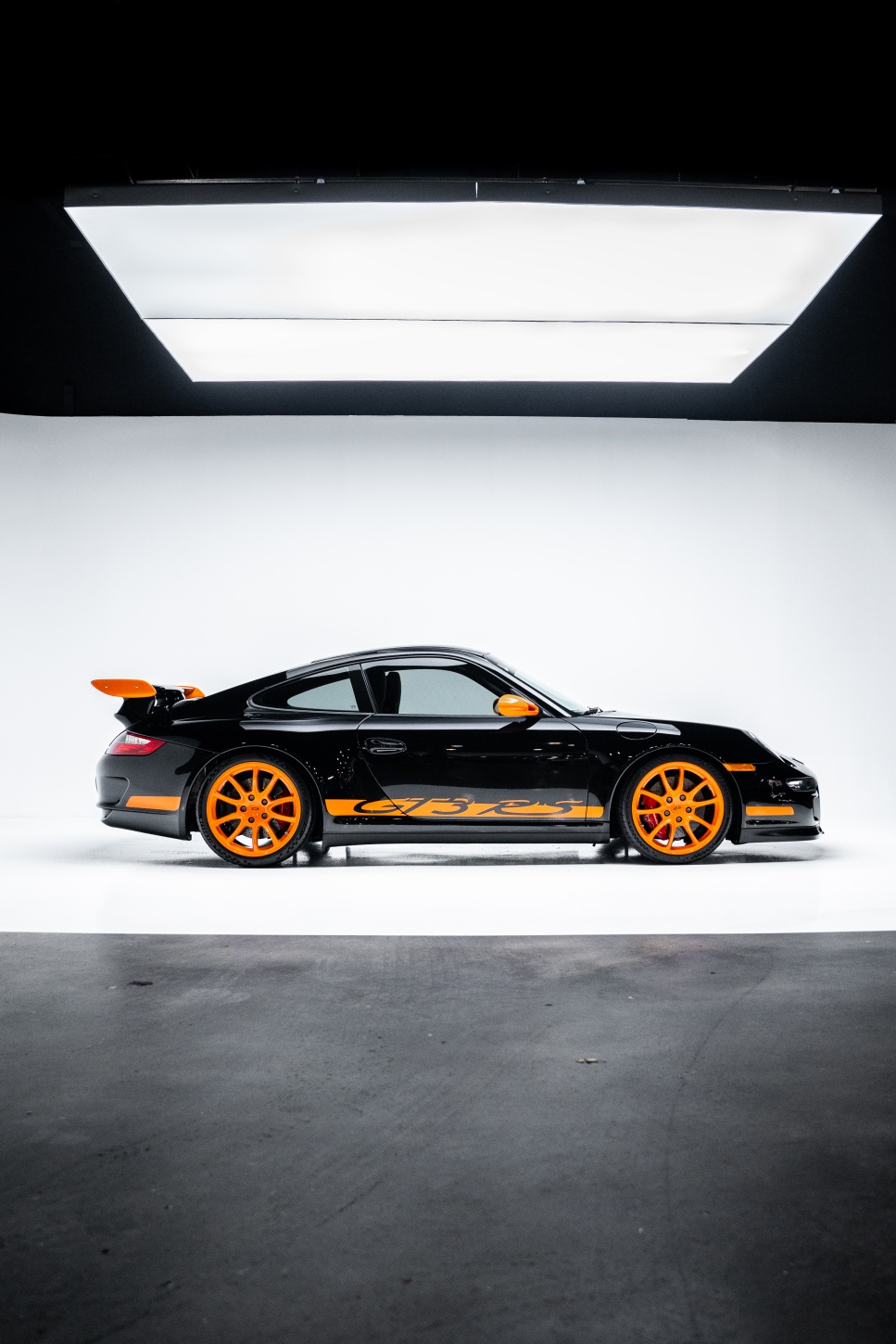 Black and orange Porsche 997 GT3 RS in studio